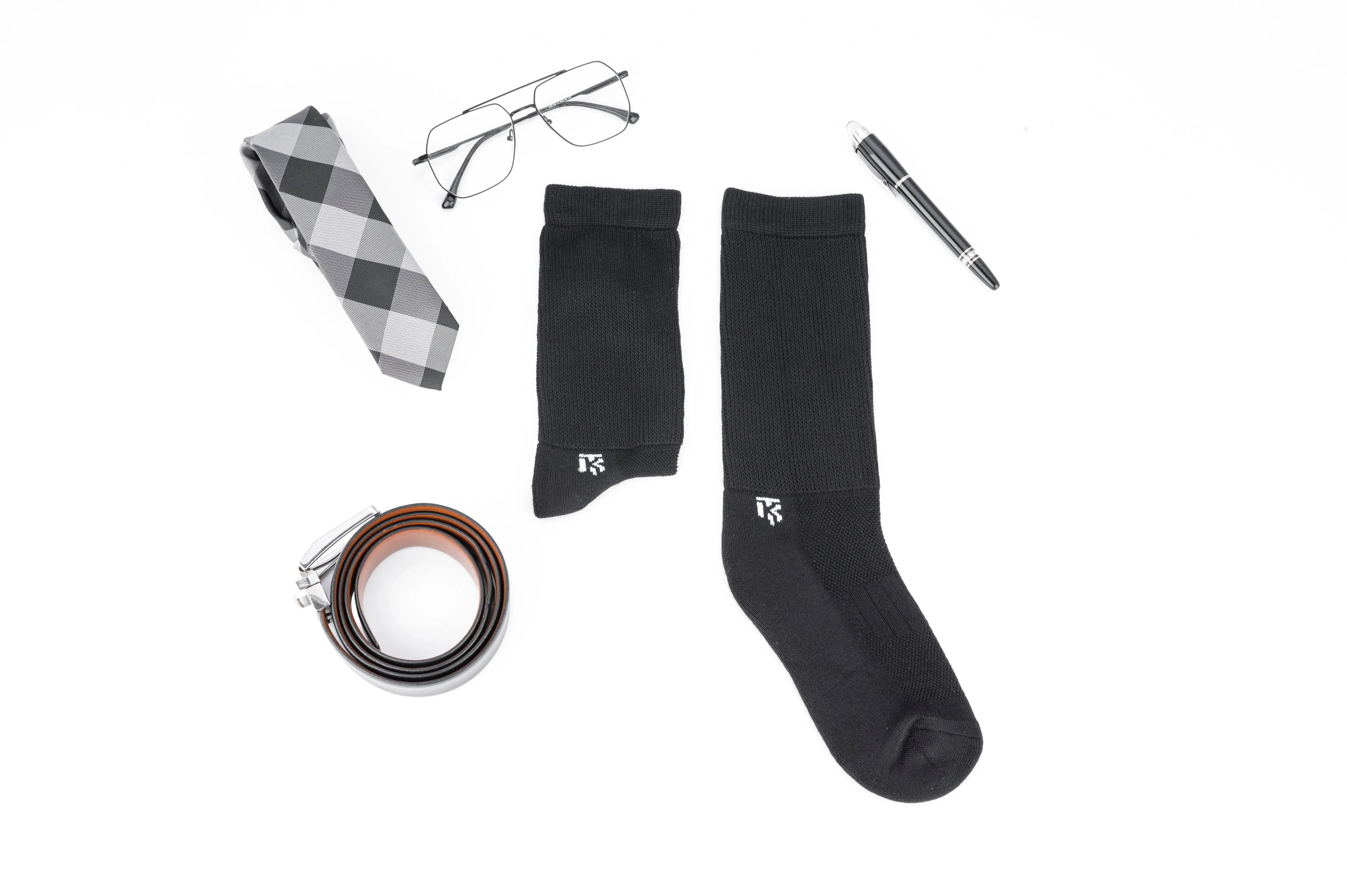 Black bamboo socks with logo, paired with tie, glasses, belt, and pen for stylish daily wear.