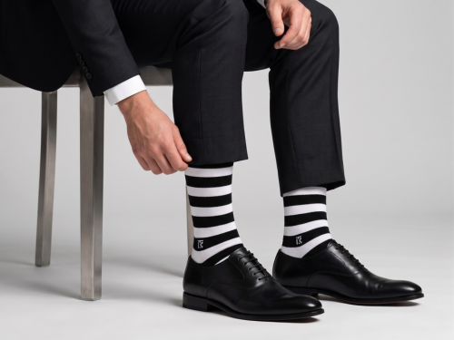 Man wearing black formal shoes with black and white striped bamboo crew socks for humid weather comfort in India