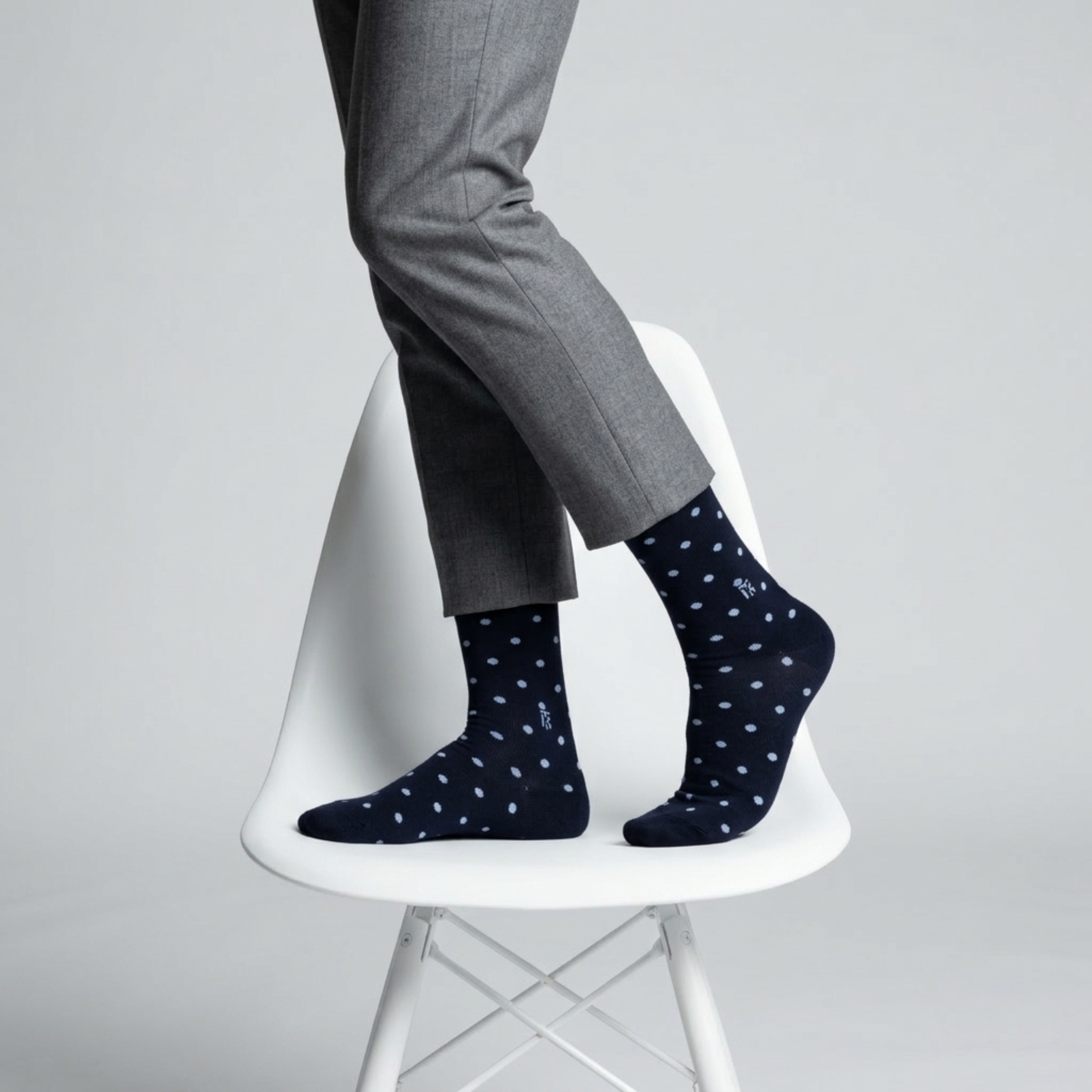 Model standing on a table wearing contrast polka black and white bamboo socks for men, stylish crew socks with breathable fabric and comfortable stretch fit for everyday wear.