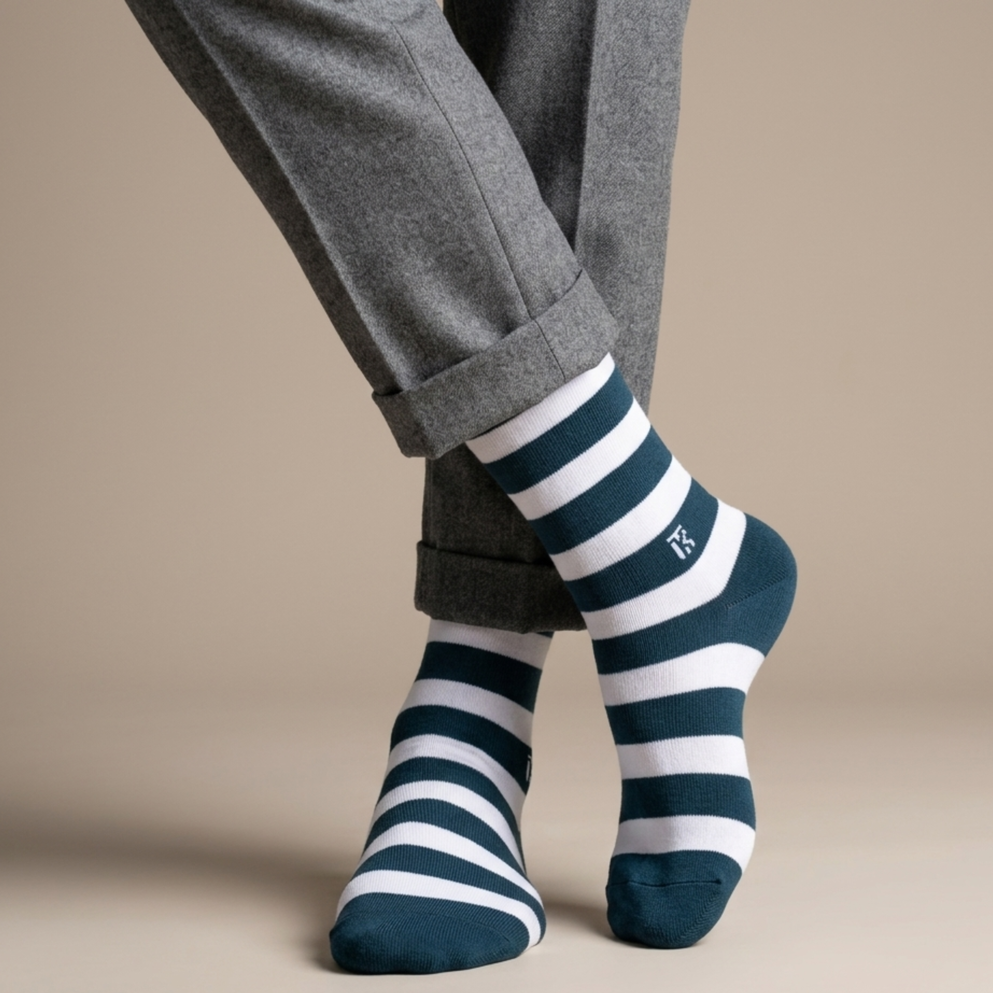 Men wearing bamboo crew socks with bold green and white horizontal stripes, paired with grey trousers in a stylish crossed-leg pose.