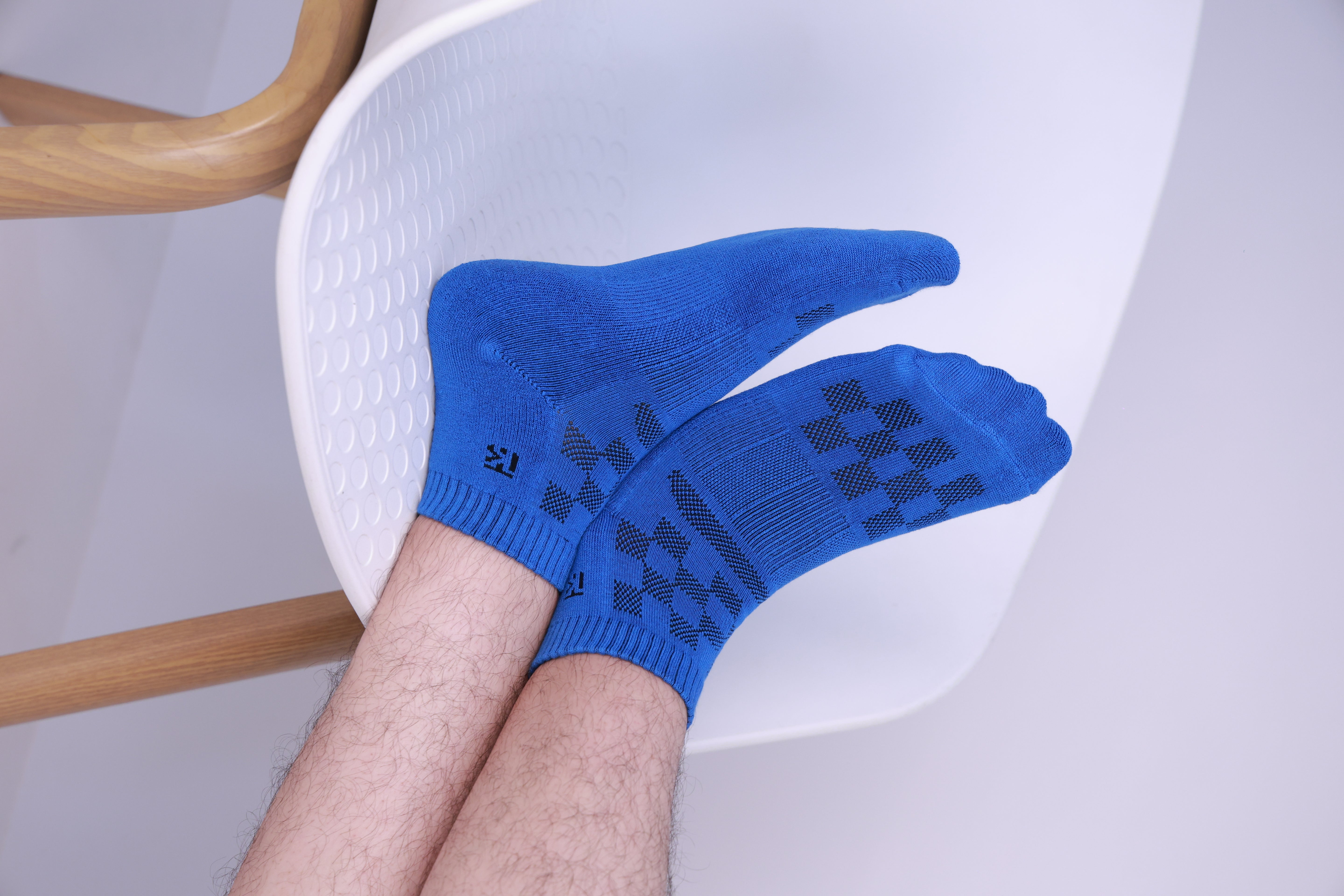 Man wearing blue bamboo ankle socks with air mesh ventilation and extra cushioning, featuring black grip patterns for breathable, soft, and comfortable everyday wear.